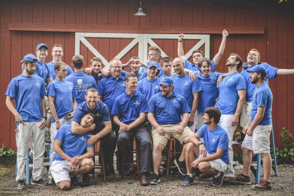 Final Touch Painting team posing in front of a house they painted